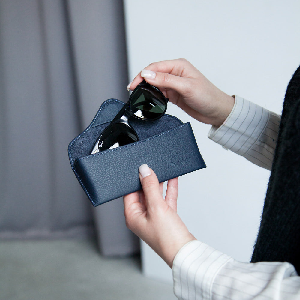 Blue leather hard glasses case held in hand with sunglasses – luxury protective eyewear case