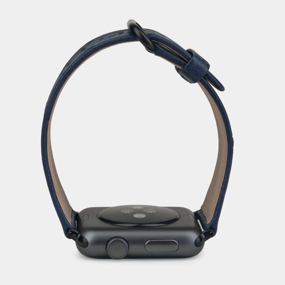Strap for the Apple Watch 41/42 mm in blue ostrich leather, with black adapters and buckle | watch case on bottom to see leather texture, inner lining and the buckle