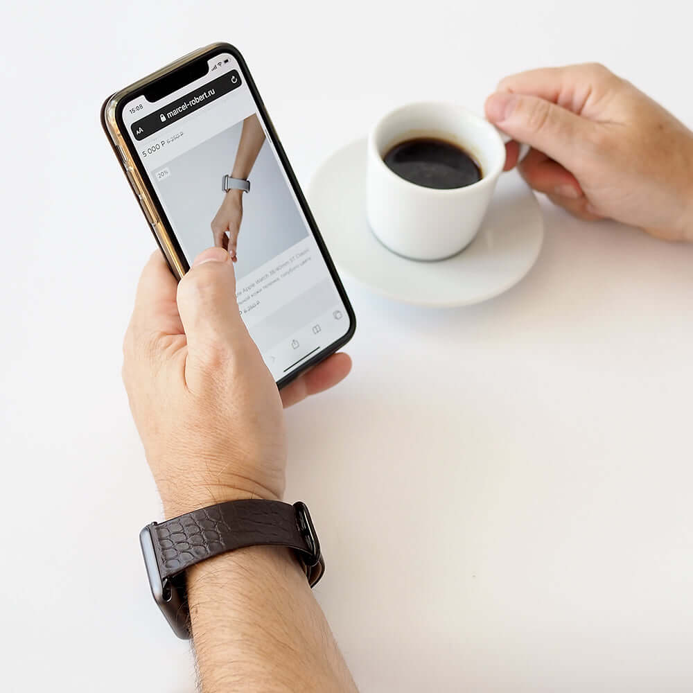 Strap for the Apple Watch 45/46 mm in brown matte alligator leather, with black adapters and buckle | lifestyle photo, the strap worn on a man's wrist