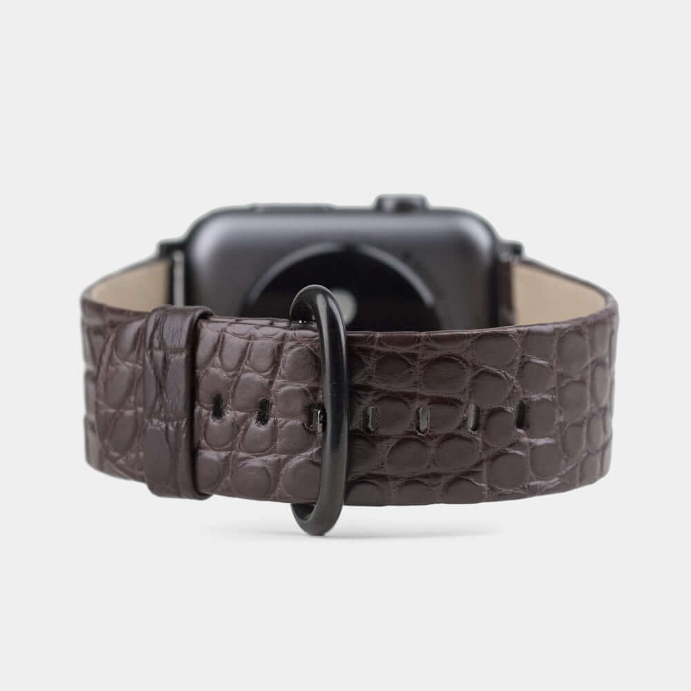 Strap for the Apple Watch 45/46 mm in brown matte alligator leather, with black adapters and buckle | watch case on bottom to see leather texture, inner lining and the buckle