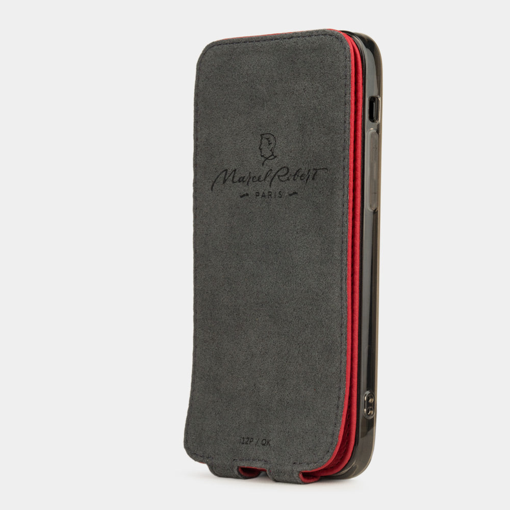 red leather flip case for iPhone 12 pro, vertical position, cover folded and secured to the back of the iPhone thanks to its integrated magnet system, revealing the grey microfiber lining