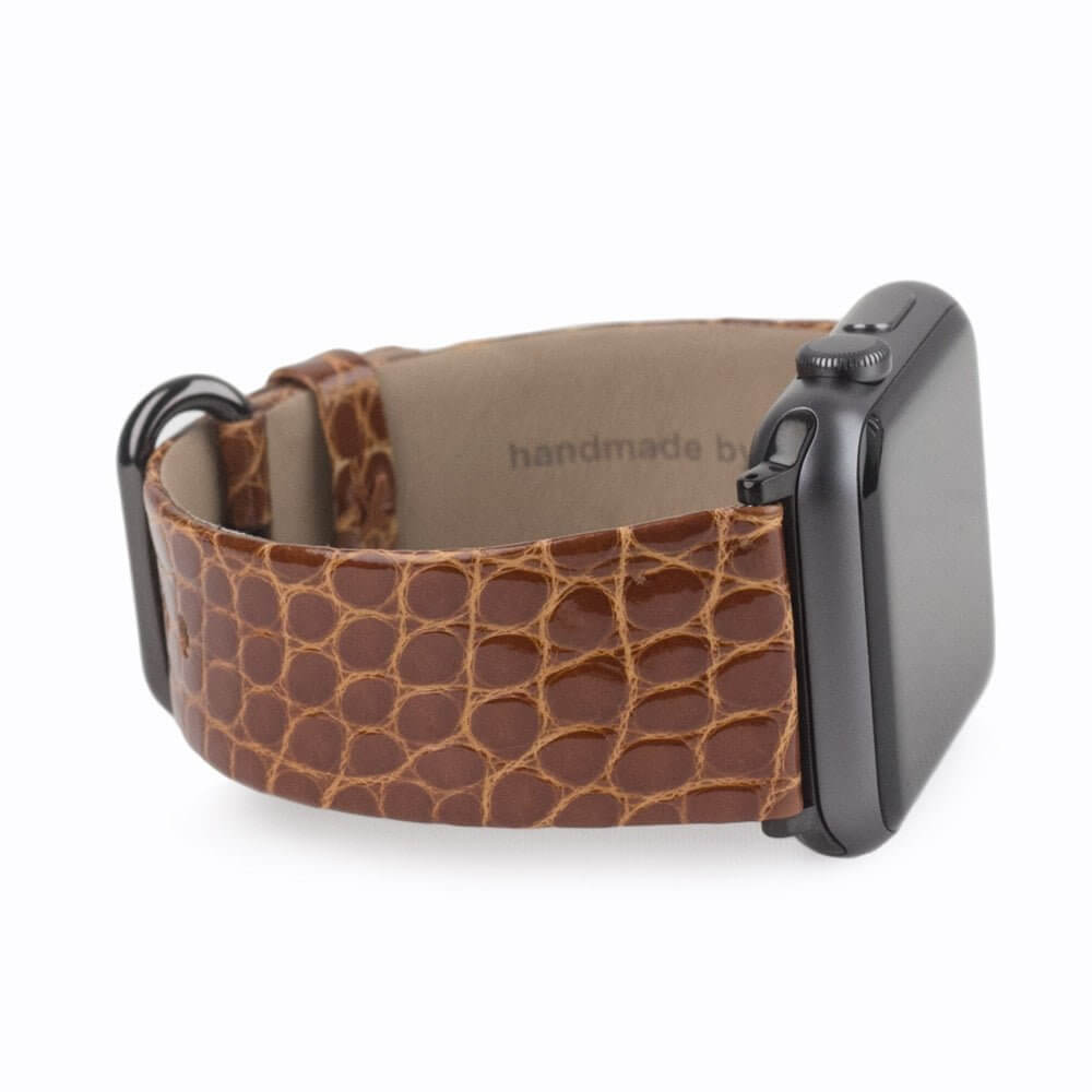 Strap for the Apple Watch 45/46 mm in Gold shiny alligator leather, with black adapters and buckle | close-up on the inner lining leather and the brand stamp