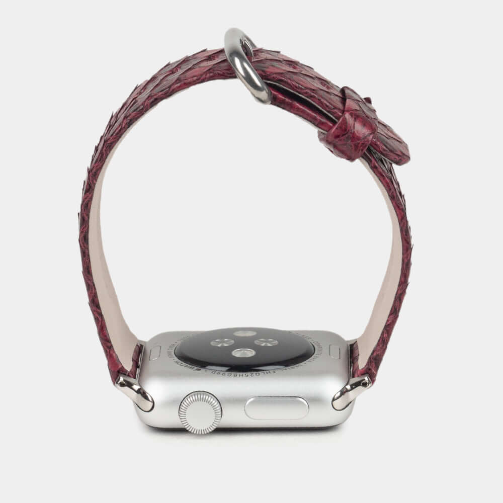 Strap for the Apple Watch 41/42 mm in bordeaux python leather, with steel adapters and buckle | watch case on bottom to see leather texture, inner lining and the buckle