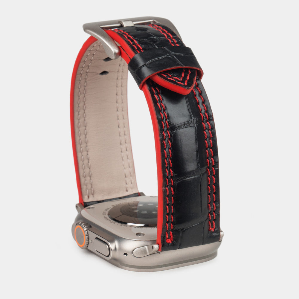 Apple Watch Ultra 49 mm in black alligator leather with red stitching and edge, with titanium adapters and buckle | close view of the square scales, the red double stitching