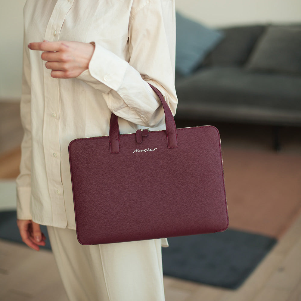 Woman carrying slim 14 inch leather laptop bag bordeaux, refined professional style