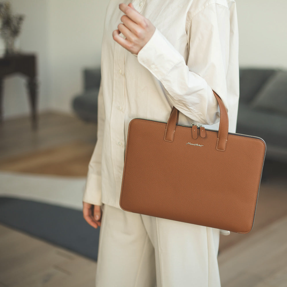 Woman carrying slim gold leather laptop bag 14 inch, elegant minimalist business briefcase