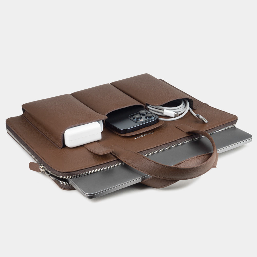 14 inch brown leather laptop bag with pockets holding laptop, charger and documents, organised layout