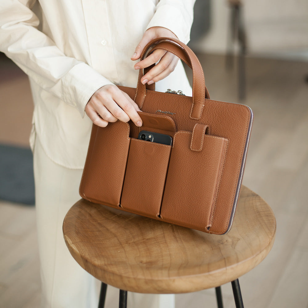 Woman carrying gold leather laptop bag 14 inch with pockets, elegant business briefcase