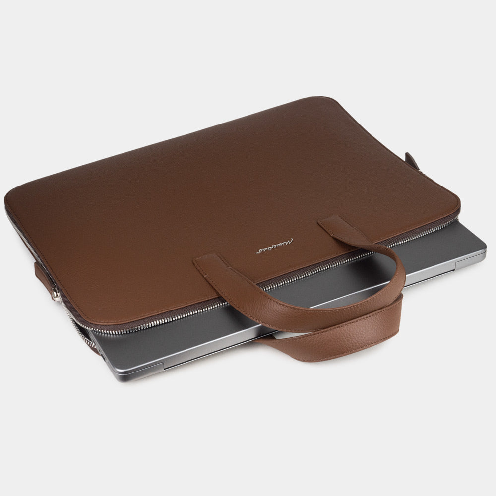 Slim 17 inch brown leather laptop bag holding laptop, structured minimalist design