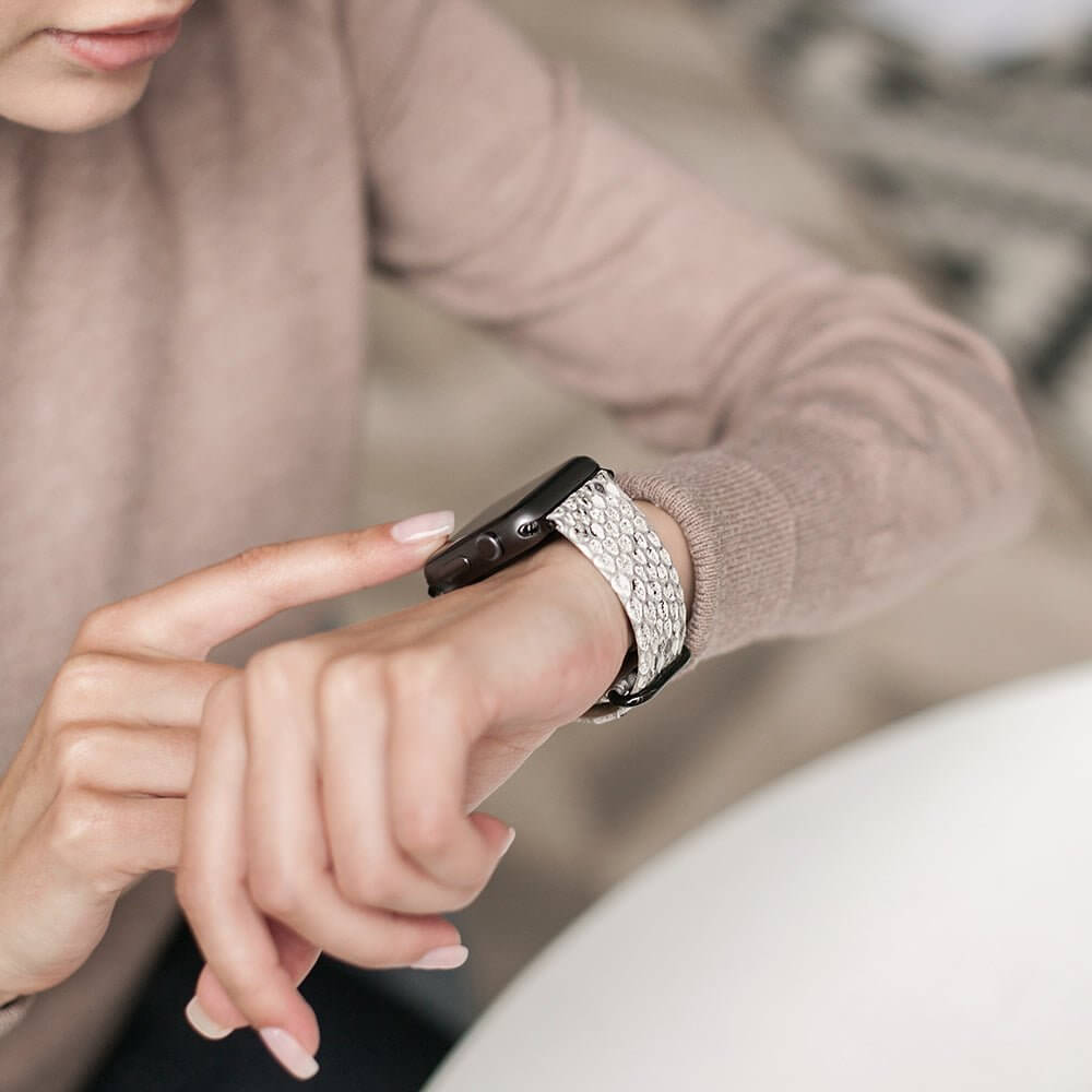 Strap for the Apple Watch 41/42 mm in natural python leather, with black adapters and buckle | lifestyle photo, the strap worn on a woman's wrist
