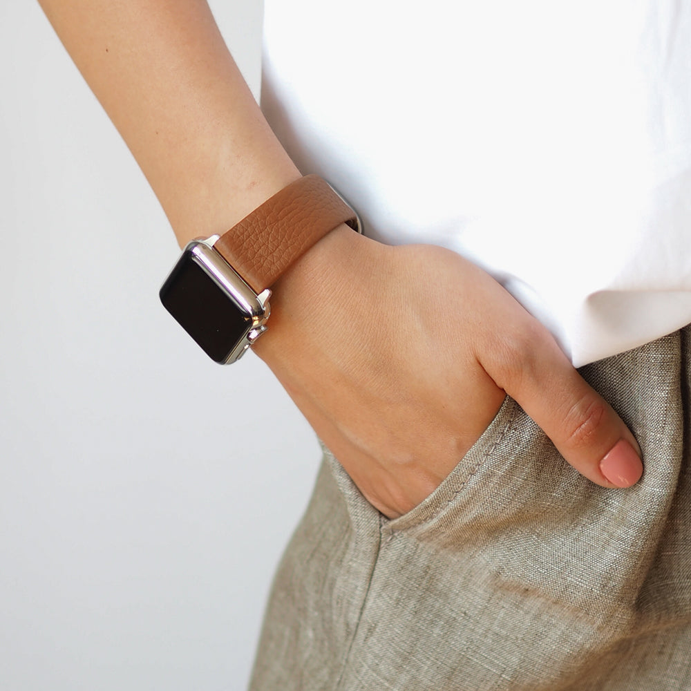 Strap for the Apple Watch 41/42 mm in Gold soft grained calfskin leather, with steel adapters and buckle | lifestyle photo, the strap worn on a woman's wrist