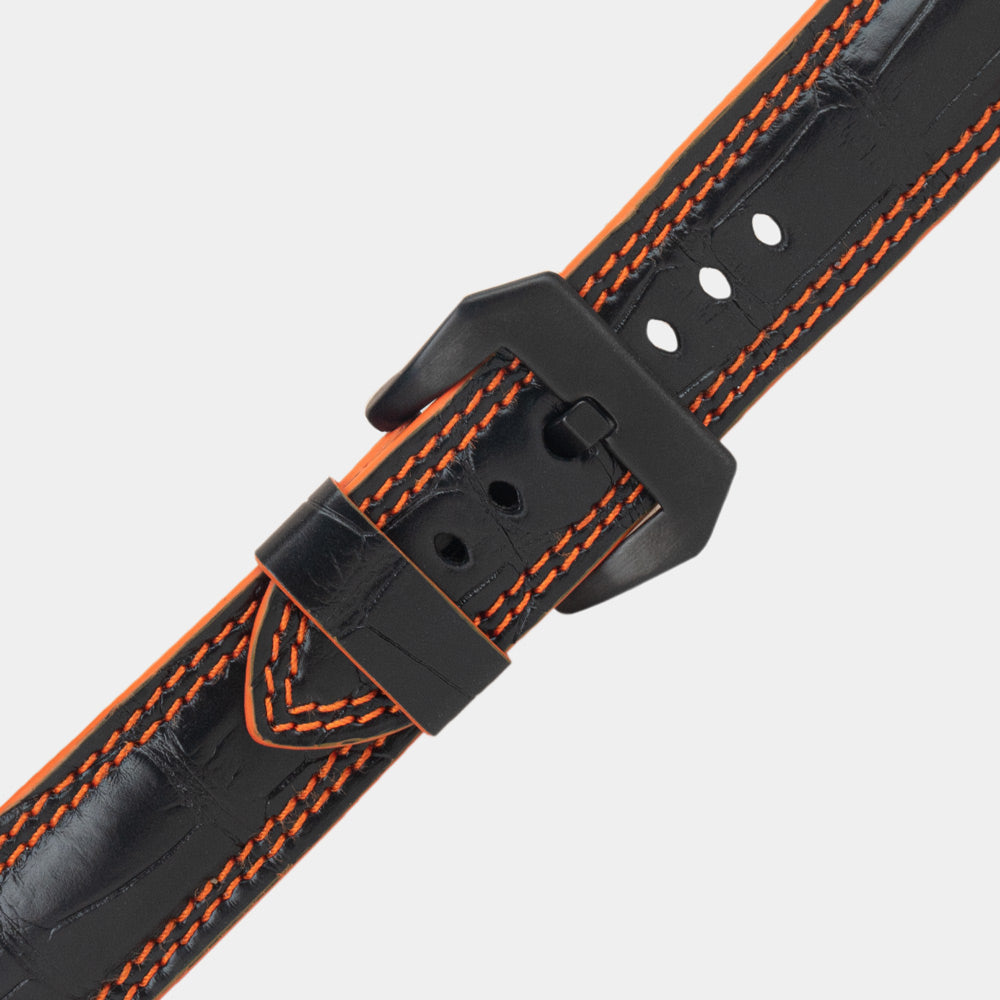 Apple Watch Ultra 49 mm in black alligator leather with orange stitching and edge, with black adapters and buckle | close view of the square scales, the orange double stitching