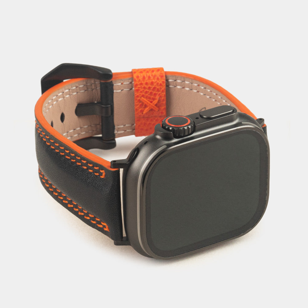 Men's Apple Watch Ultra band 49mm in black smooth calfskin leather with orange edge finish and its black color adapters - front dial view