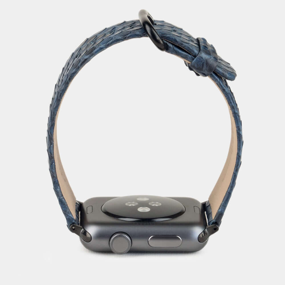 Strap for the Apple Watch 41/42 mm in blue python leather, with black adapters and buckle | watch case on bottom to see leather texture, inner lining and the buckle