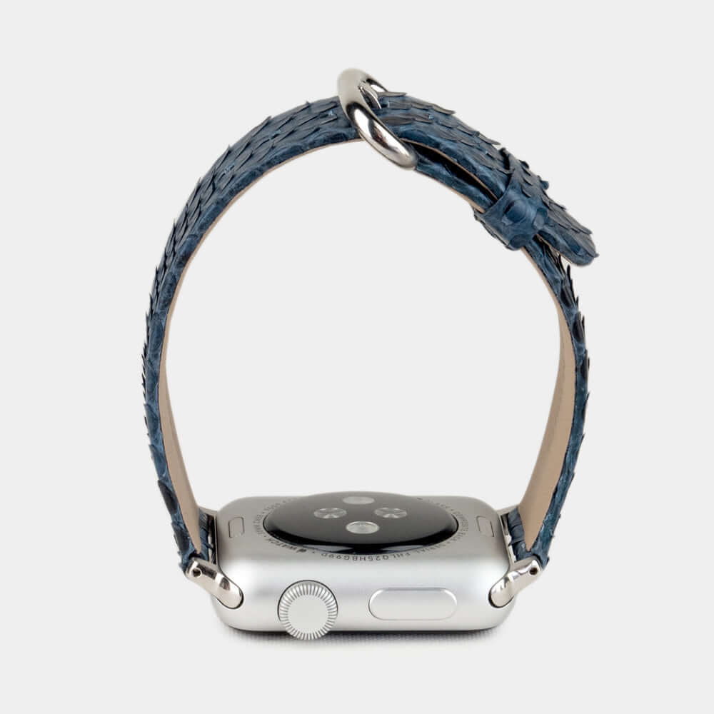 Strap for the Apple Watch 41/42 mm in blue python leather, with steel adapters and buckle | watch case on bottom to see leather texture, inner lining and the buckle