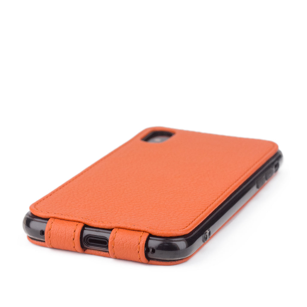 Orange leather flip case for iPhone X - close-up of the bottom edge showing the Lightning port opening