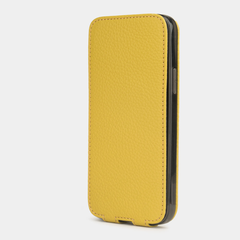 yellow leather iphone 12 mini flip case in an upright position, cover closes securely thanks to its integrated magnet system