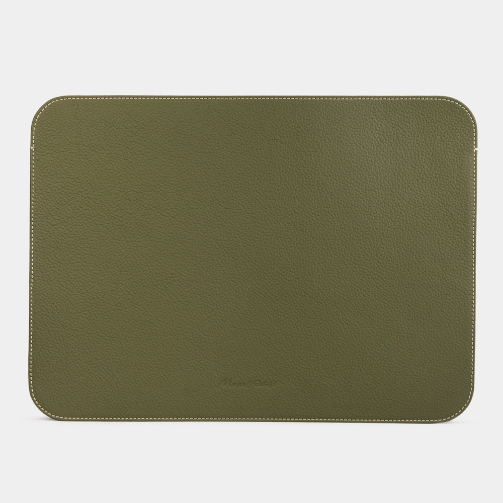 Green 14 inch leather laptop sleeve with MacBook partially inserted, slim minimalist MacBook case