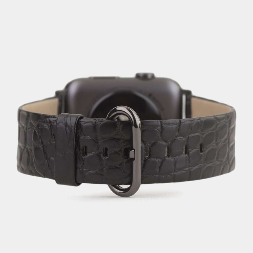 Strap for the Apple Watch 45/46 mm in black matte alligator leather, with black adapters and buckle | watch case on bottom to see leather texture, inner lining and the buckle