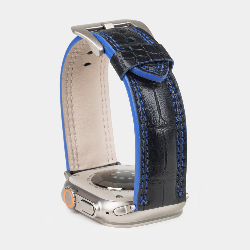 Apple Watch Ultra 49 mm in black alligator leather with blue stitching and edge, with titanium adapters and buckle | close view of the square scales, the blue double stitching