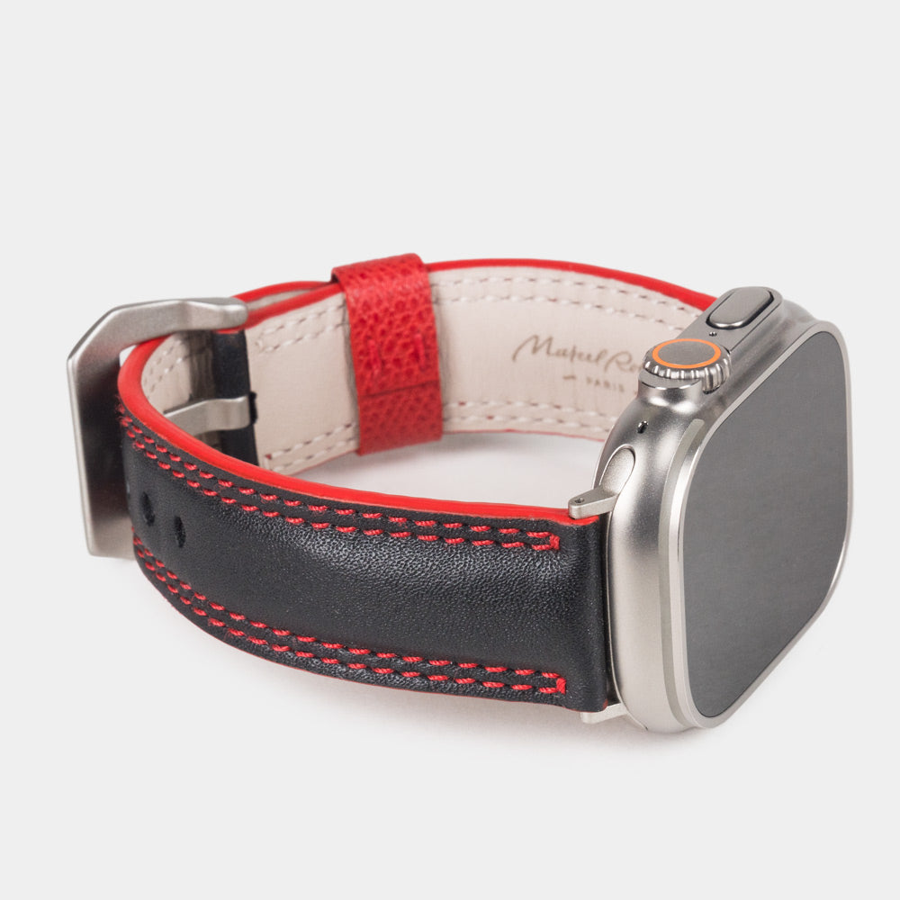 Men's Apple Watch Ultra band 49mm in black smooth calfskin leather with red edge finish and its titanium color adapters - 3/4 profile view