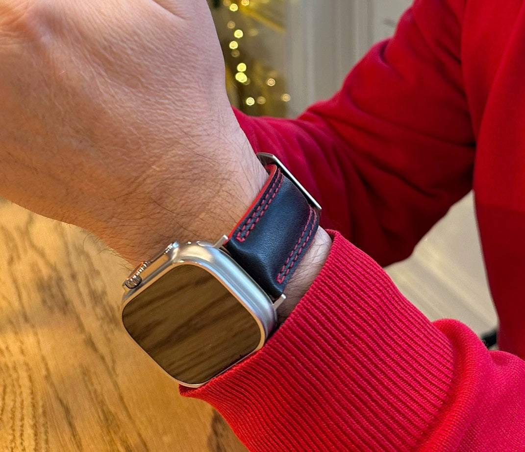 Men's Apple Watch Ultra band 49mm in black smooth calfskin leather with red edge finish and its titanium color adapters - worn on wrist view