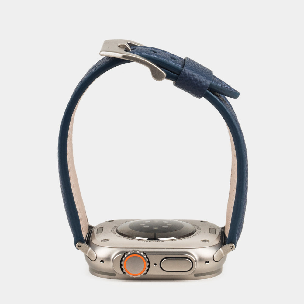 Men's Apple Watch Ultra band 49mm in blue Epsom calfskin - side view, band open above the case back showing its curve and painted edge