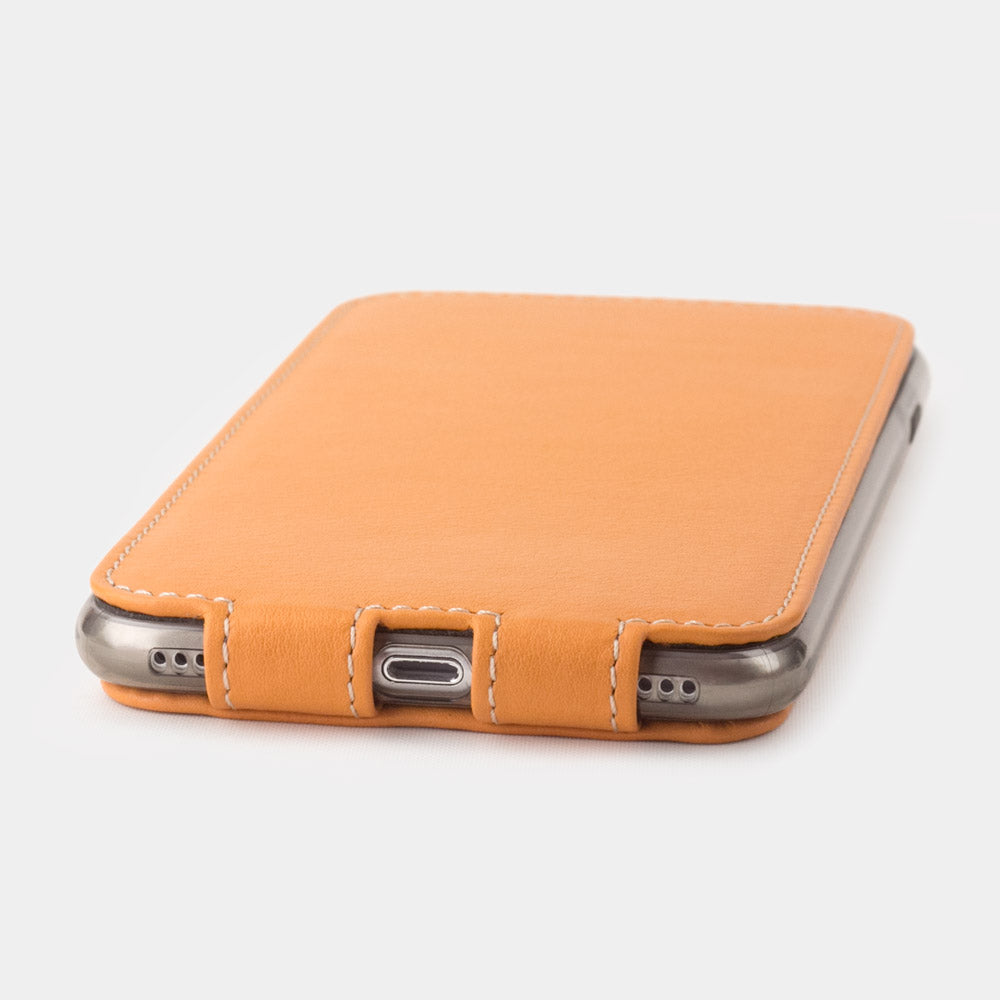 Ocker leather flip case for iPhone SE - flat side view displaying ultra-thin handcrafted design, Lightning port opening and precise edge finishing