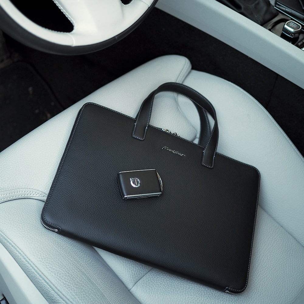 Men’s slim 14 inch leather laptop bag black placed on car leather seat, executive minimalist briefcase