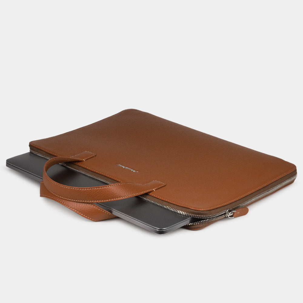 Slim 14 inch leather laptop bag gold holding laptop and documents, minimalist business layout