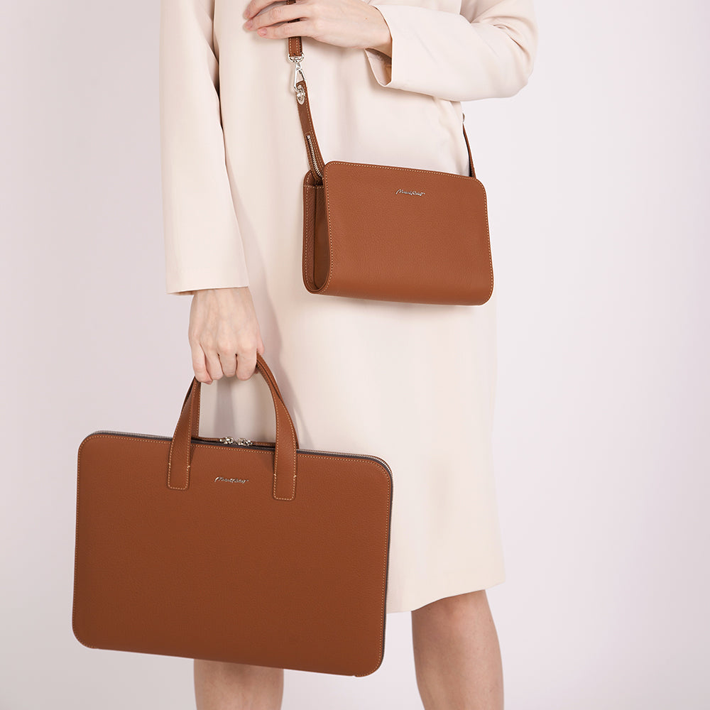 Woman carrying gold 17 inch leather laptop bag, elegant slim business briefcase