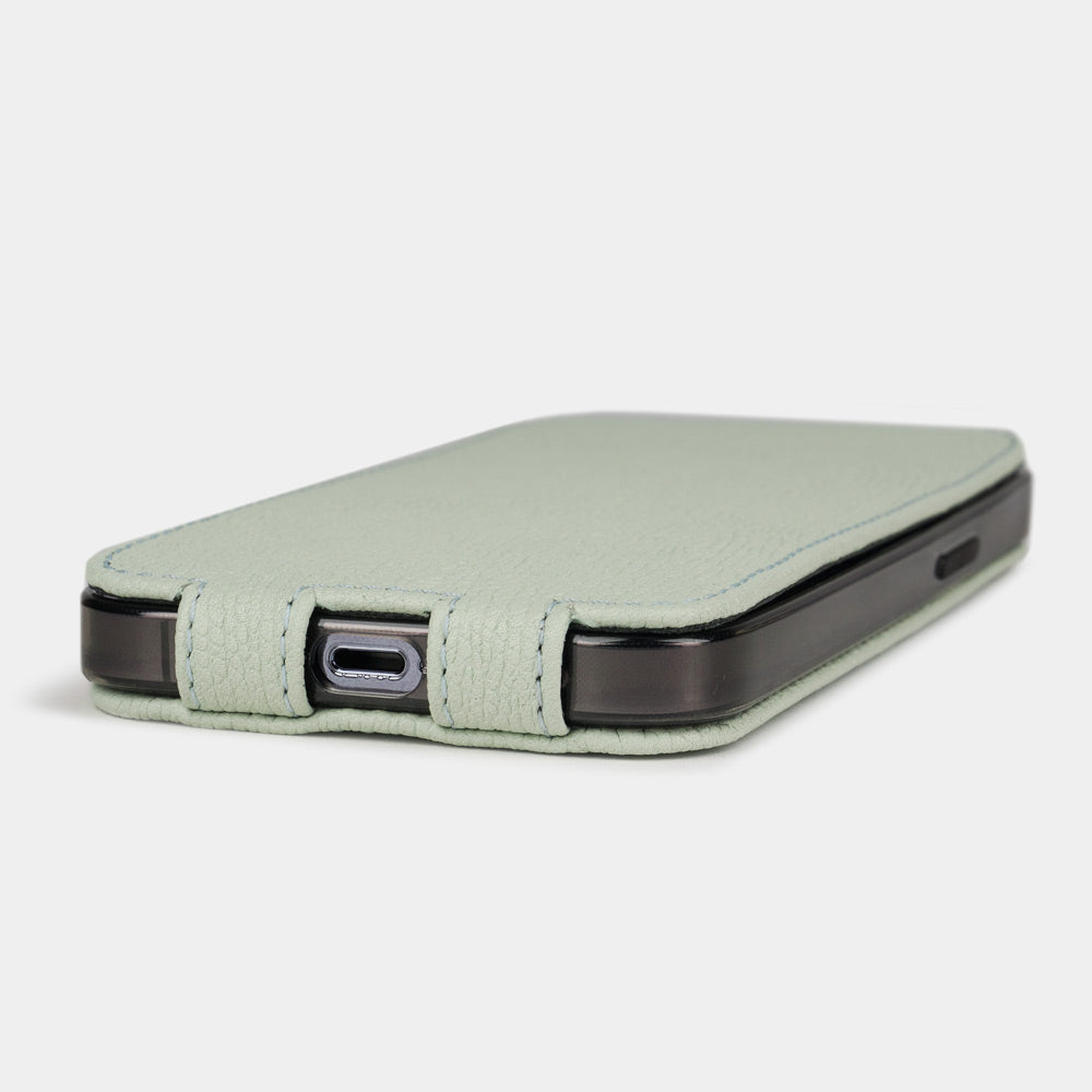 Pastel green calfskin leather flip case for iPhone 15 – bottom view with USB-C port opening and hand-stitched edges