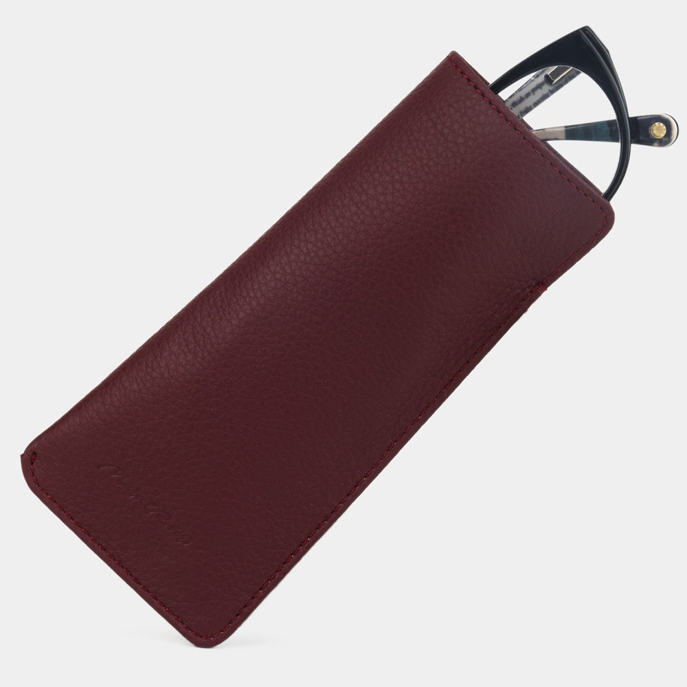 Pocket glasses pouch in bordeaux calfskin with glasses slipping out of the top