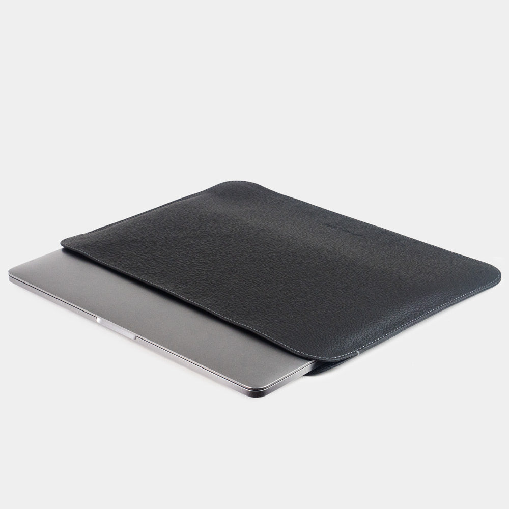 Slim black leather laptop sleeve 14 inch holding MacBook, minimalist protective laptop case