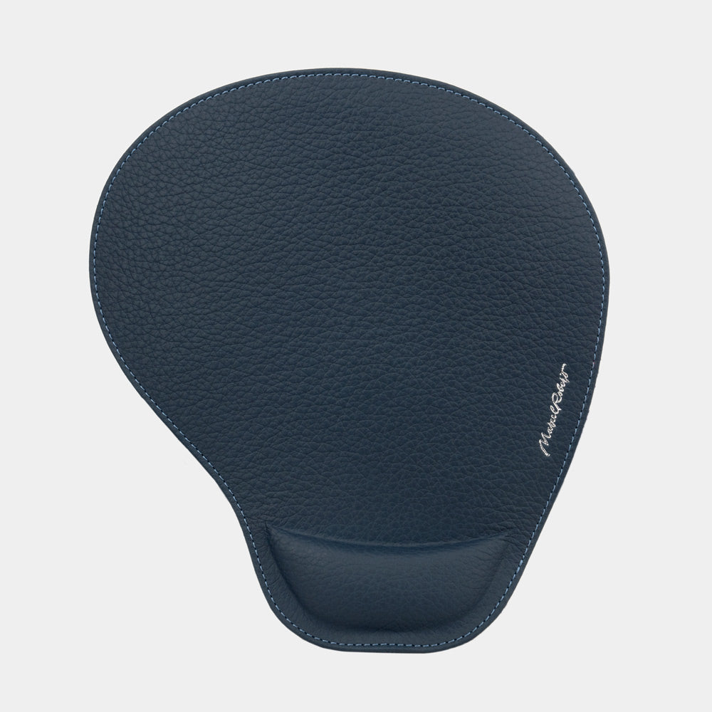 Blue leather mouse pad seen from above, teardrop shape and embossed signature