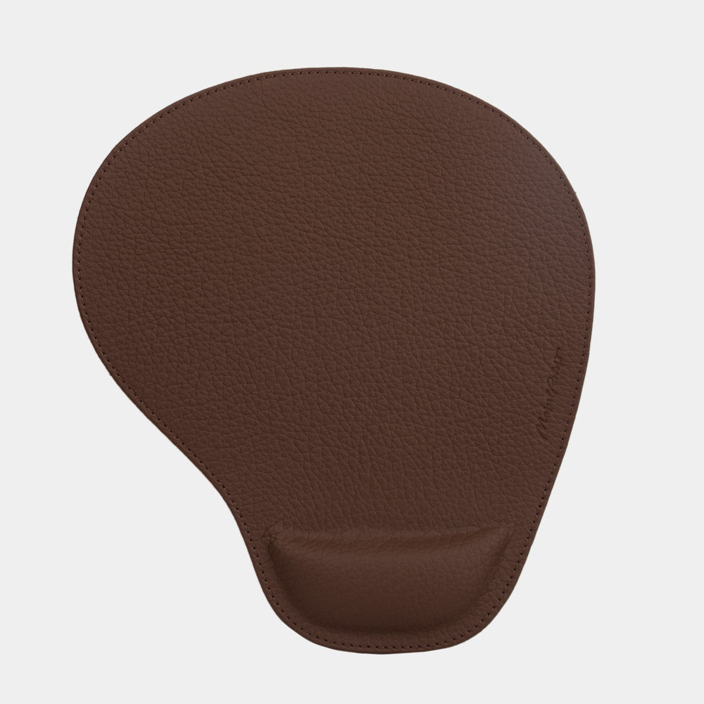 Brown leather mouse pad seen from above, teardrop shape and embossed signature