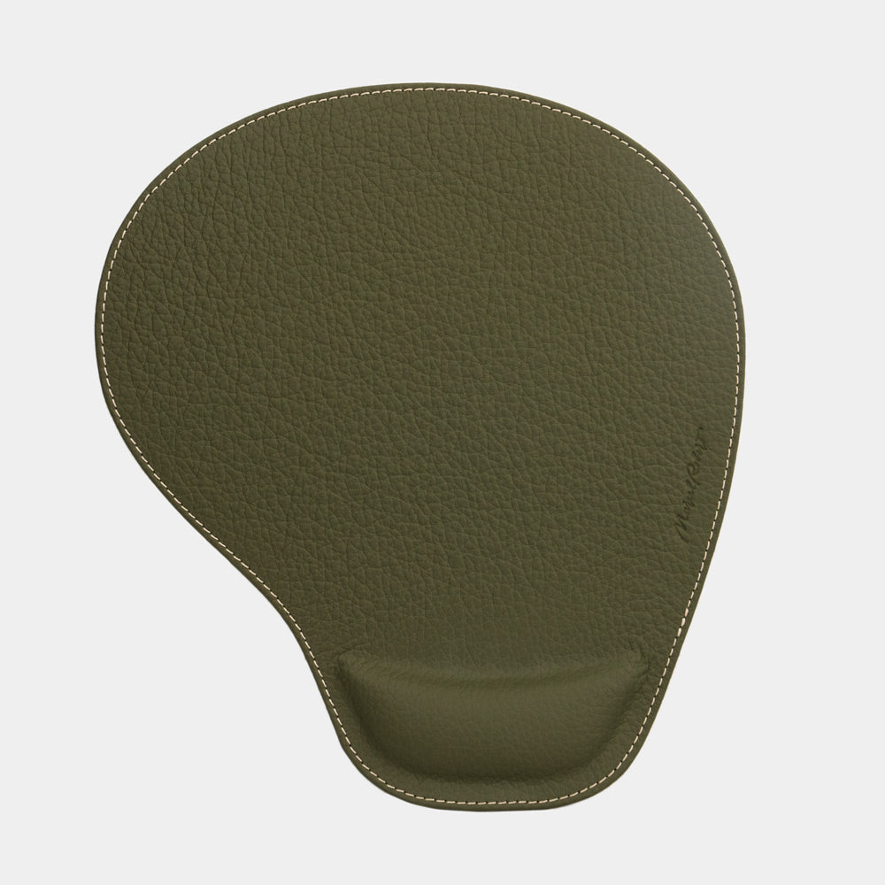 Green leather mouse pad seen from above, teardrop shape and embossed signature