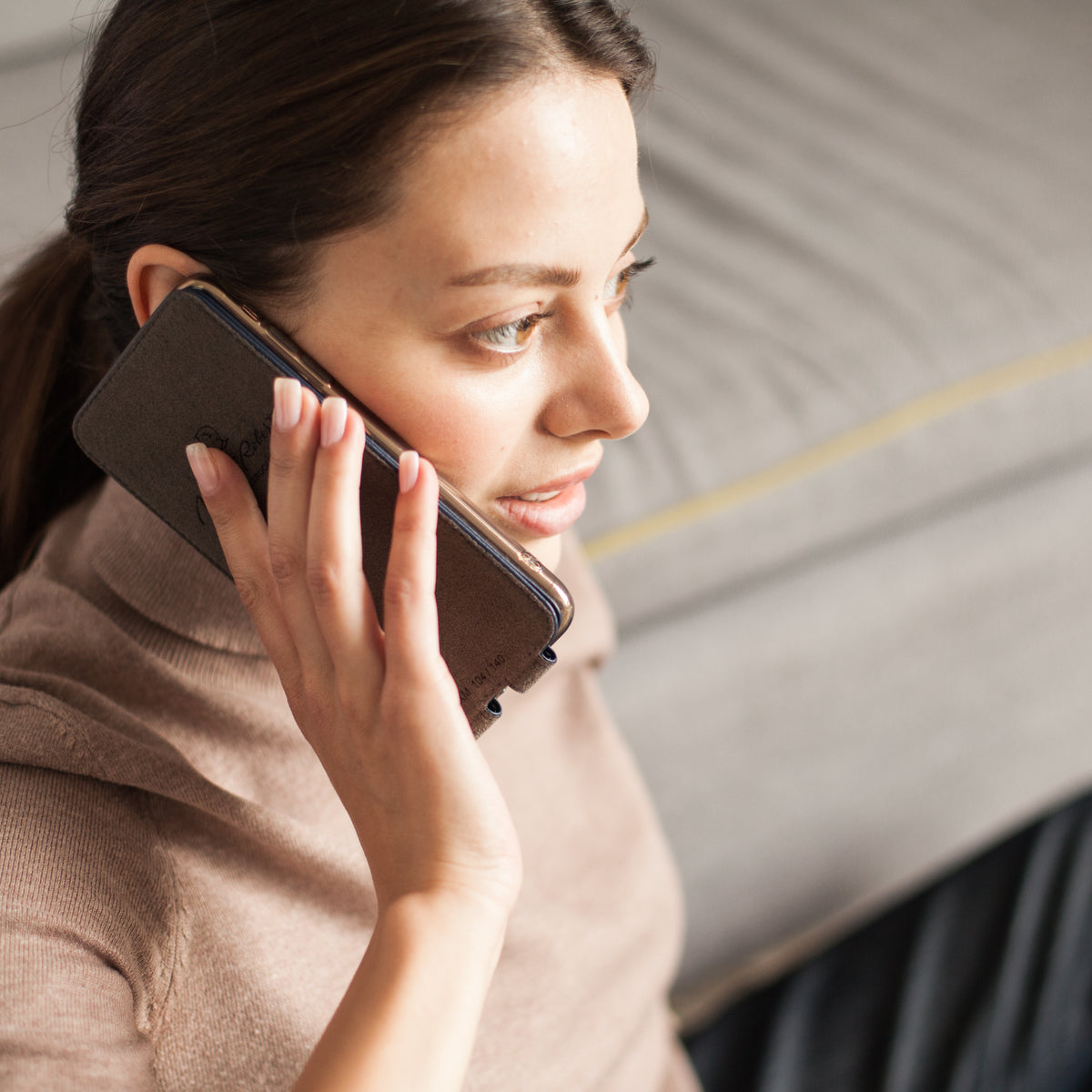 iPhone 14 flip case made with blue premium leather – lifestyle photo: the soft flap folds back behind the phone for a call