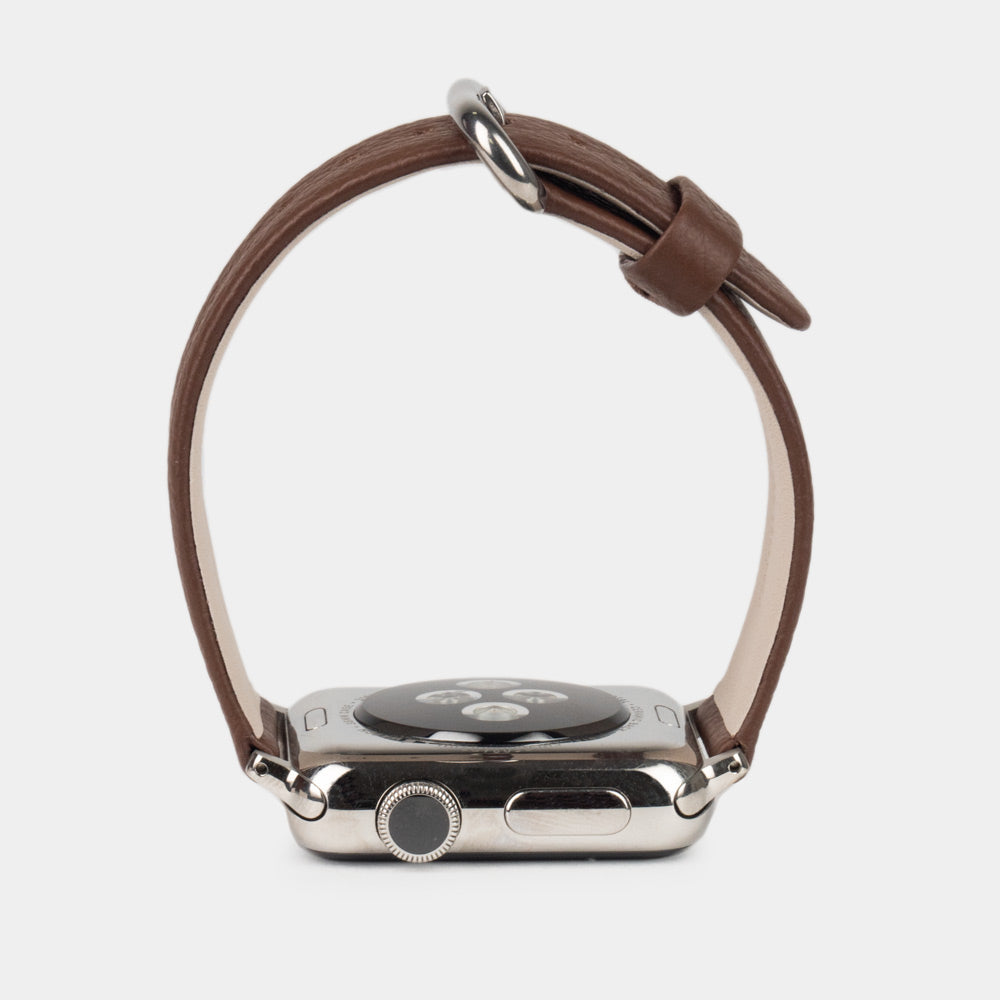 Strap for the Apple Watch 41/42 mm in brown soft grained calfskin leather, with steel adapters and buckle | watch case on bottom to see leather texture, inner lining and the buckle