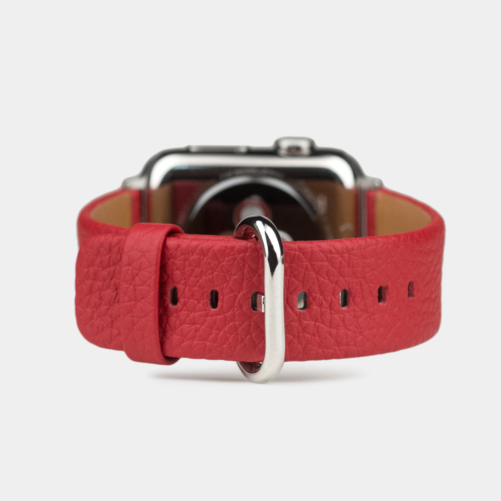 Strap for the Apple Watch 41/42 mm in red soft grained calfskin leather, with steel adapters and buckle | watch case on bottom to see leather texture, inner lining and the buckle