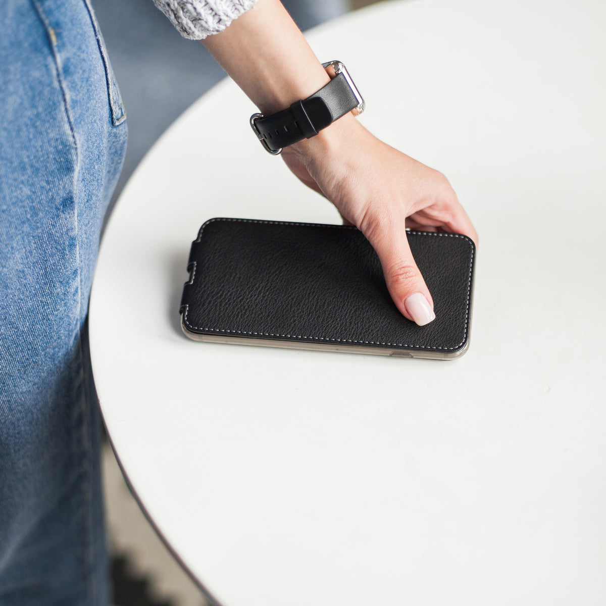 Strap for the Apple Watch 41/42 mm in smooth black calfskin, with steel adapters and buckle | lifestyle photo, the band worn on a woman's wrist