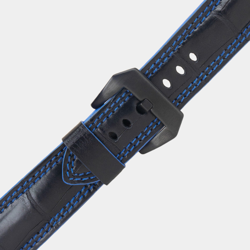Apple Watch Ultra 49 mm in black alligator leather with blue stitching and edge, with black adapters and buckle | close view of the square scales, the blue double stitching