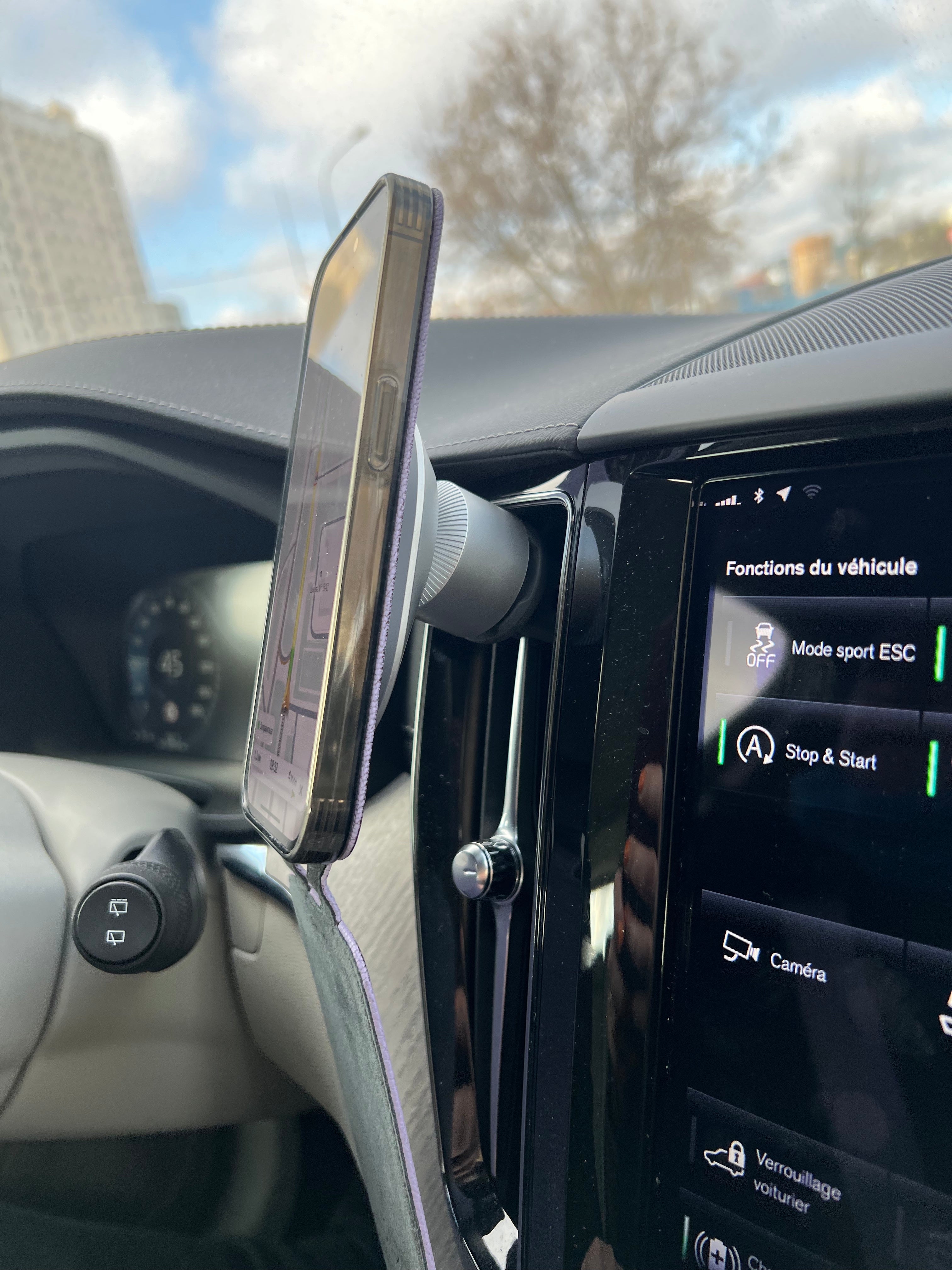 iPhone 14 Pro flip case made with gold premium leather – lifestyle photo: the case held on a MagSafe car mount, screen showing GPS navigation
