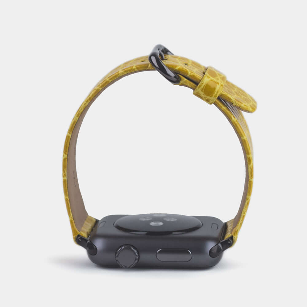 Strap for the Apple Watch 45/46 mm in yellow shiny alligator leather, with black adapters and buckle | watch case on bottom to see leather texture, inner lining and the buckle